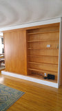 A librarian's (our client) dream home library and TV Unit.  Incredible MCM inspired library/ bookcase and built in TV unit featuring a stunning sliding door.  The bookcase  which stretches over 30ft ​ boast ​seven shelves ​running all the way through ​offering plenty of ​ ​display space for books, art, ​etc​  TV unit is hidden with a beautiful 54" wide sliding door oozing out Danish charm and practicality..