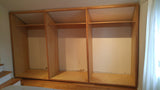 Custom storage solutions - Closet with solid oak wood doors, designed for a  room with ceiling at an angle.