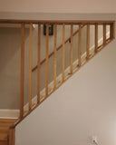 The soaring solid white oak balusters from staircase to the ceiling add a touch MCM  flair as well safety with out enclosing the  narrow staircase too much. The railing was specifically designed so balusters can be taken down anytime if a big item need to taken to floor above or vice versa.  #whiteaok #mcm #ralingdesign #customrailing