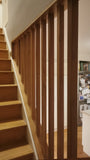The soaring solid white oak balusters from staircase to the ceiling add a touch MCM  flair as well safety with out enclosing the  narrow staircase too much. The railing was specifically designed so balusters can be taken down anytime if a big item need to taken to floor above or vice versa.  #whiteaok #mcm #ralingdesign #customrailing