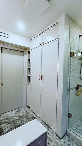By hiding the stacked washer and dryer behind retractable doors created a cleaner and more stylish look in this multi use bathroom.