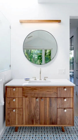 Wooden walnut  bathroom vanity with round mirror and white countertop