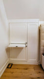 Custom-built angled cabinet designed for an unusual space under a sloped ceiling beside the bed, adding not only functional storage but also features a convenient pull-out nightstand.