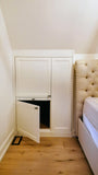 Custom-built angled cabinet designed for an unusual space under a sloped ceiling beside the bed, adding not only functional storage but also features a convenient pull-out nightstand.