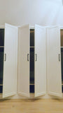 A closet design   specifically tailored to fit rooms with sloped or slanted ceilings, featuring beveled shaker doors. The design maximizes storage while creating both a functional and beautiful space.