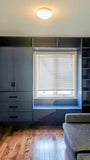A custom floor-to-ceiling, wall-to-wall storage unit designed to frame a window. The design includes a spacious section featuring two doors and three drawers, perfect for keeping items out of sight. It also incorporates open shelving, which is ideal for displaying decor, books, bar essentials, or electronics. Additionally, the unit features a custom bench-cum-chest to provide both extra seating and integrated storage.