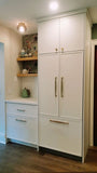 This kitchen, for instance, showcases a blend of beautiful and classic design. The upper cabinets feature a slim shaker panel design, while the base cabinets have a thin rail with rounded edges. Additionally, the kitchen includes a pantry discreetly tucked into an alcove with an arched opening, as well as panel-ready refrigerator and dishwasher. The peninsula island, complete with a sink and seating, is designed to be a central focal point.