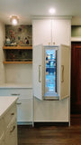 This kitchen, for instance, showcases a blend of beautiful and classic design. The upper cabinets feature a slim shaker panel design, while the base cabinets have a thin rail with rounded edges. Additionally, the kitchen includes a pantry discreetly tucked into an alcove with an arched opening, as well as panel-ready refrigerator and dishwasher. The peninsula island, complete with a sink and seating, is designed to be a central focal point.