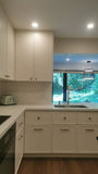 This kitchen, for instance, showcases a blend of beautiful and classic design. The upper cabinets feature a slim shaker panel design, while the base cabinets have a thin rail with rounded edges. Additionally, the kitchen includes a pantry discreetly tucked into an alcove with an arched opening, as well as panel-ready refrigerator and dishwasher. The peninsula island, complete with a sink and seating, is designed to be a central focal point.