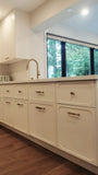 This kitchen, for instance, showcases a blend of beautiful and classic design. The upper cabinets feature a slim shaker panel design, while the base cabinets have a thin rail with rounded edges. Additionally, the kitchen includes a pantry discreetly tucked into an alcove with an arched opening, as well as panel-ready refrigerator and dishwasher. The peninsula island, complete with a sink and seating, is designed to be a central focal point.