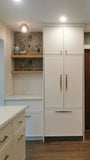 This kitchen, for instance, showcases a blend of beautiful and classic design. The upper cabinets feature a slim shaker panel design, while the base cabinets have a thin rail with rounded edges. Additionally, the kitchen includes a pantry discreetly tucked into an alcove with an arched opening, as well as panel-ready refrigerator and dishwasher. The peninsula island, complete with a sink and seating, is designed to be a central focal point.
