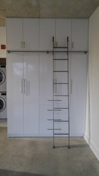 Modern white closet boasts custom built metal ladder and a 7ft long metal rail .  Ladder with multiple hooks was specially designed so it can be used not only for the tall  closet in the bedroom but also in the kitchen. Allowing  for maximum versatility on multiple rails and to store it elsewhere.
