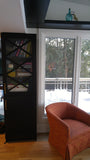 Every home can use more storage.  A half wall that separates the entry to this sun filled room is used to display a gorgeous bookshelf with distinct glass door sporting a hand carved  criss-cross design plus a decorative film.  The floating shelves fits in perfectly with any home that prefer shelf spaces with clean and well defined lines.  The idea also saves up on space and gives you a stylish display area that you can use in various forms!