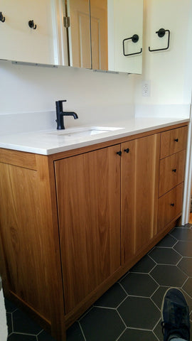 This gorgeous vanity features solid wood frame and door & drawer fronts built from white oak. Modern lines and beautiful wood grains makes it a perfect statement in any contemporary bathroom. Two precisely inset doors and three functional drawers with soft-close slides offer plenty of storage for a growing family. To maximize the drawers width the under-mount sink was offset to one side.