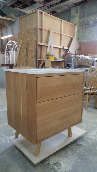 This 30" gorgeous MCM  inspired vanity features solid wood frame, legs and drawer fronts built from white oak.   Modern lines and beautiful  & warm wood grains makes it a perfect statement in any contemporary bathroom.  Two functional  drawers with soft-close slides offer plenty of storage.  The counter top is a low maintenance and durable single edge white quartz  with an under-mount ceramic sink