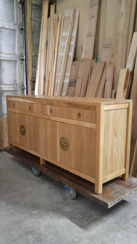 A modern makeover to an age-old distinct Chinese simple clean line design.  This remarkable sideboard is built from  stunning  warm & gorgeous solid white oak wood and boasts beautiful classic Chinese round brass cabinet face-plate door & drawer pulls.  It provides a large amount of storage space to hold a great deal, from dishes and table linen to board games.  67" W x 30" H  x 18" D