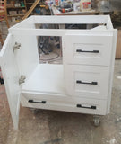 Shown in the photos is a 30" wide custom floating vanity designed to accommodate a off centered sink.  Cabinet built  from solid poplar wood.  Shaker style fronts.  Soft close drawers and doors.  Painted white.   30" W x  18" D x  32" (ht)  Send us your rough sketch with dimensions along with your inspiration photos of your dream bathroom vanity,