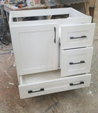 Shown in the photos is a 30" wide custom floating vanity designed to accommodate a off centered sink.  Cabinet built  from solid poplar wood.  Shaker style fronts.  Soft close drawers and doors.  Painted white.   30" W x  18" D x  32" (ht)  Send us your rough sketch with dimensions along with your inspiration photos of your dream bathroom vanity,