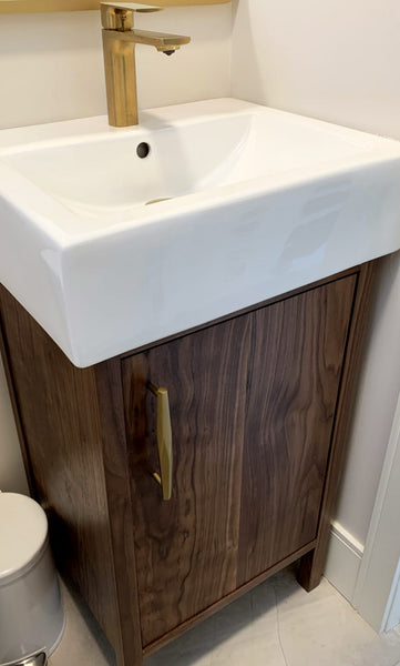 Shown in the photos is an 20.5" " wide  custom vanity built from solid walnut with a ceramic integrated sink.  Clean line & contemporary design  with 6" high legs. The compact size makes it the perfect vanity for a powder room,