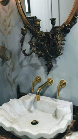 Amazing shell shaped marble sink from Inde-Art paired with an antique mirror & gold faucet gives  designer Michelle Hanna's bathroom a luxurious grand Parisian style.