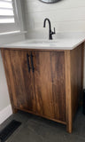 This gorgeous modern clean line bathroom vanity built from solid poplar wood with a white quartz  top and a ceramic sink adds a perfect rustic & warn touch to this bathroom.