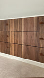 An absolutely spectacular 13 ft long MCM inspired dresser / bedroom unit. Custom build unit boast 9 soft close drawers with under mount slides and 2 door panels on either ends. Which can easily handle all storage needs with ease and still look splendid! Fronts built from beautiful walnut with exceptional grain pattern throughout. The vintage pulls and shell shape handles add a time less feel. A sleek and streamlined white exterior with recessed kick giving it the floating look