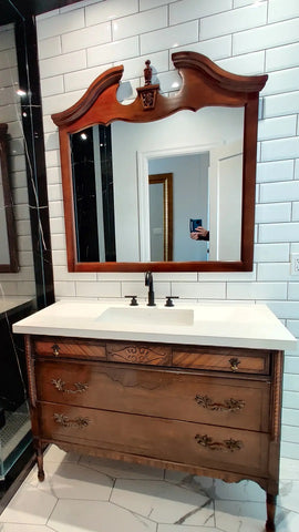 The vintage dresser was modified to accommodate the plumbing  including  new under-mount soft close  drawer boxes with cut outs and white quartz top with an under-mount sink.  Allowing the luxurious vintage look & feel but also the modern convenience & functionality.