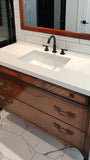 The vintage dresser was modified to accommodate the plumbing  including  new under-mount soft close  drawer boxes with cut outs and white quartz top with an under-mount sink.  Allowing the luxurious vintage look & feel but also the modern convenience & functionality.