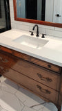 The vintage dresser was modified to accommodate the plumbing  including  new under-mount soft close  drawer boxes with cut outs and white quartz top with an under-mount sink.  Allowing the luxurious vintage look & feel but also the modern convenience & functionality.