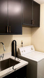 There’s no reason your laundry room shouldn’t be as beautiful as the rest of your home.  An outdated laundry room  was transformed into a bold  & sophisticated space with Asian inspired black custom cabinets & brass pulls.  A gorgeous sink cabinet with  black veined quartz counter top and extra deep stainless steel sink.  Wall cabinets provide plenty of shelf space and  hanging rod.
