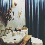 Amazing shell shaped marble sink from Inde-Art paired with an antique mirror & gold faucet gives  designer Michelle Hanna's bathroom a luxurious grand Parisian style.