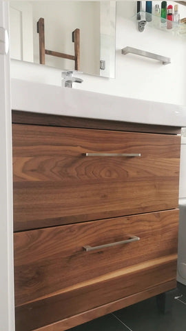 A bland IKEA bathroom vanity was transformed into an elegant modern cabinet by replacing existing fronts with beautiful warm solid walnut drawer fronts. Also to customized storage space 3 drawer unit was turned into 2 drawer instead, to accommodate taller items.