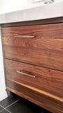 A bland IKEA bathroom vanity was transformed into an elegant modern cabinet by replacing existing fronts with beautiful warm solid walnut  drawer fronts.   Also to customized storage space 3 drawer unit was turned into 2 drawer instead, to accommodate taller items.
