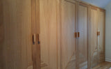 Custom storage solutions - Closet with solid oak wood doors, designed for a  room with ceiling at an angle.