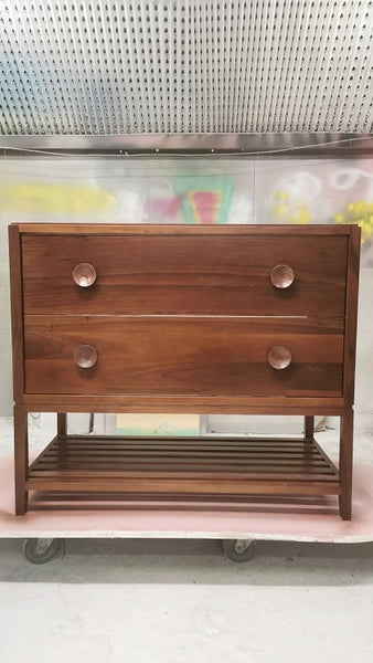 The hand-crafted solid walnut wood bathroom vanity boasts  2 deep soft close drawers and a storage shelf.  A unique & sleek design featuring tapered legs, 1/4" reveal at the top,  & inset drawers which are set back 1/4" to reveal the frame.  The concave walnut wood pulls/knob gives the cabinet a retro / mid-century feel