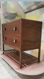 The hand-crafted solid walnut wood bathroom vanity boasts  2 deep soft close drawers and a storage shelf.  A unique & sleek design featuring tapered legs, 1/4" reveal at the top,  & inset drawers which are set back 1/4" to reveal the frame.  The concave walnut wood pulls/knob gives the cabinet a retro / mid-century feel