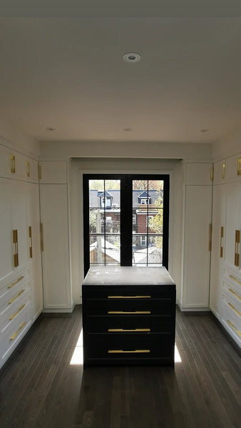 U shaped custom closet, designed to fit this unique space in a third floor bedroom of downtown house, featuring inset shaker style fronts with bead design and a gorgeous black closet island with additional drawers & pull out for a laundry hamper.  The closets provide ample hanging, drawer, and shelf space for clothing , etc. 