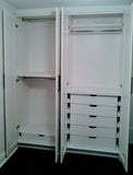 A double-tiered hanging system for folded pants, skirts, jackets on one side and combination of drawers, shelving and hanging rod on the other side, coupled with shaker style doors give this bedroom custom built closet a contemporary & classic style with all the storage one may  need.  
